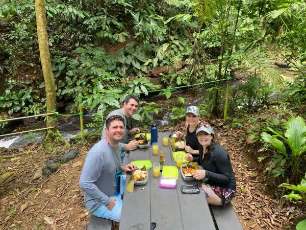 Friends having a Costa Rican picnic style lunch next to a river at Hacienda Ebano