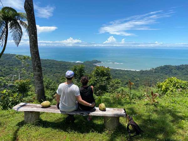 Pareja contemplando la hermosa vista al mar desde lo mas alto de la montaña